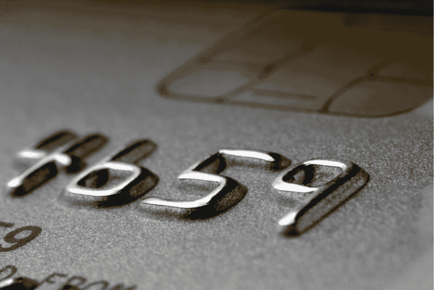 Chiffres embossés d’une carte bancaire avec puce, vus en gros plan.