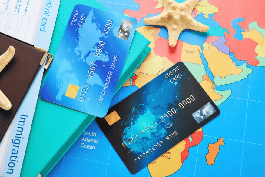 Cartes de crédit sur une carte du monde, évoquant les voyages et les dépenses à l’international.