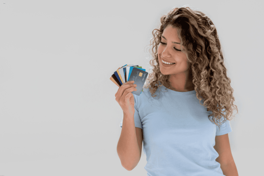 Jeune femme souriante tenant plusieurs cartes bancaires pour étudiants