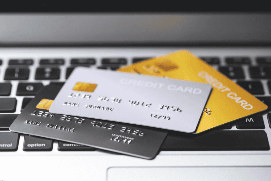 Cartes de crédit posées sur un clavier d’ordinateur portable.