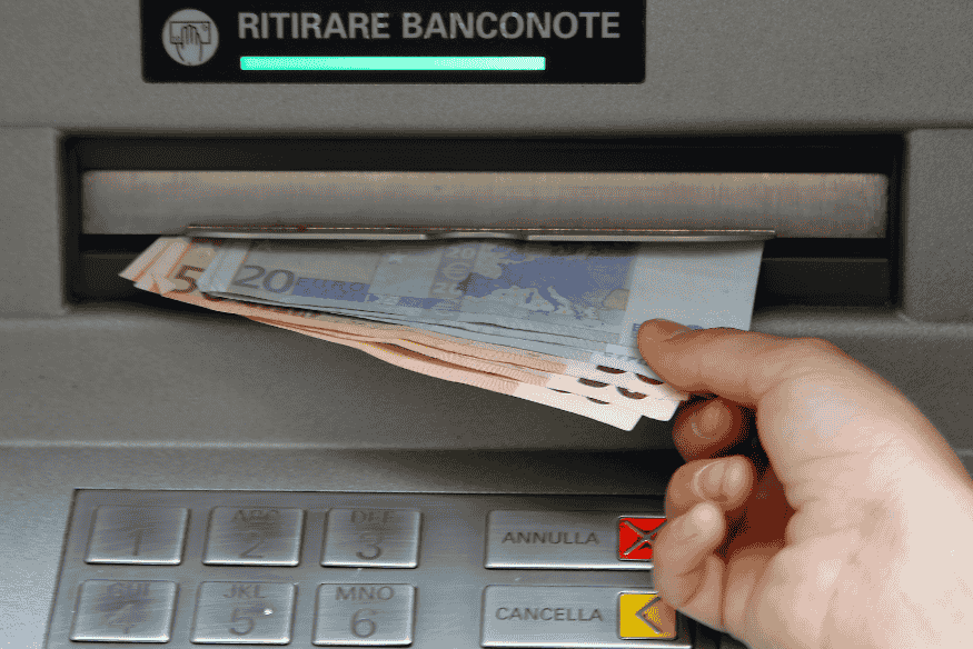 Retrait d'argent liquide dans un distributeur automatique, représentant le découvert bancaire fréquent en France.