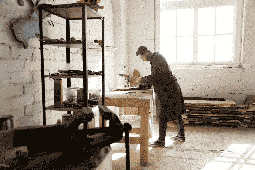 Travailleur indépendant dans son atelier, représentant les défis des auto-entrepreneurs face au taux d’endettement.