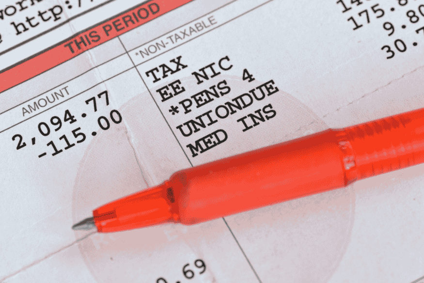 Bulletin de salaire avec montant net, taxes et cotisations sociales, marqué d’un stylo rouge.