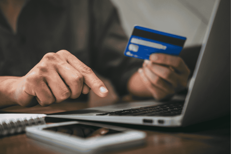 Personne effectuant un achat en ligne avec une carte bancaire, représentant l’utilisation immédiate après approbation.