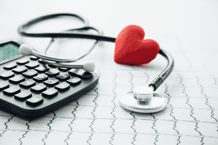 Stéthoscope, cœur rouge et calculatrice représentant l’importance d’un fonds d’urgence pour faire face aux imprévus médicaux.