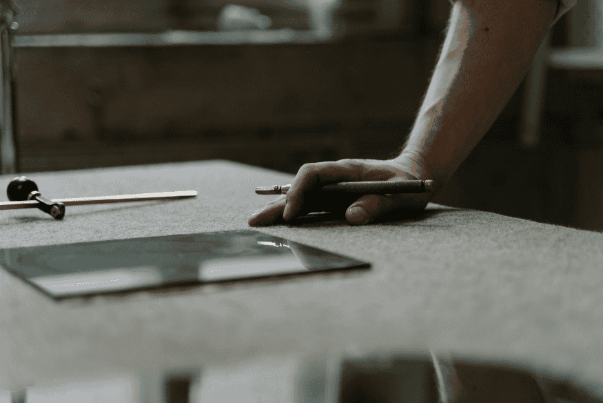 Main posée sur un bureau avec un stylo, représentant la prise de décision et la planification financière pour éliminer les dettes avec la méthode boule de neige.