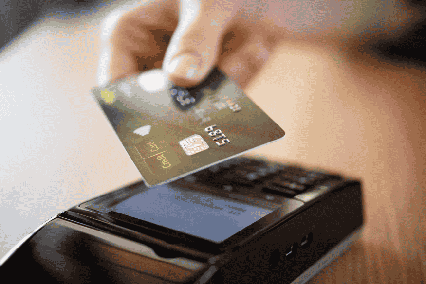 Carte de crédit utilisée sur terminal pour paiement, montrant la gestion du plafond bancaire