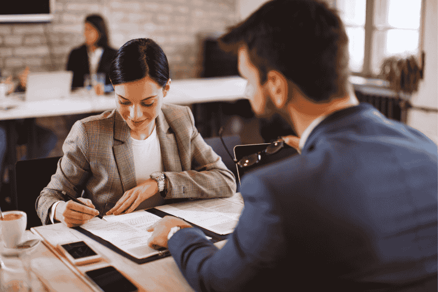 Signature d’un acte notarié entre deux personnes dans un cadre professionnel, garantissant la sécurité juridique d’un prêt entre particuliers.