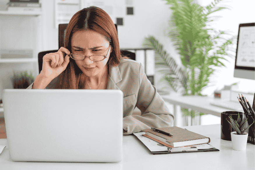 Femme freelance préoccupée analysant des conditions de prêt sur son ordinateur portable dans un bureau moderne.
