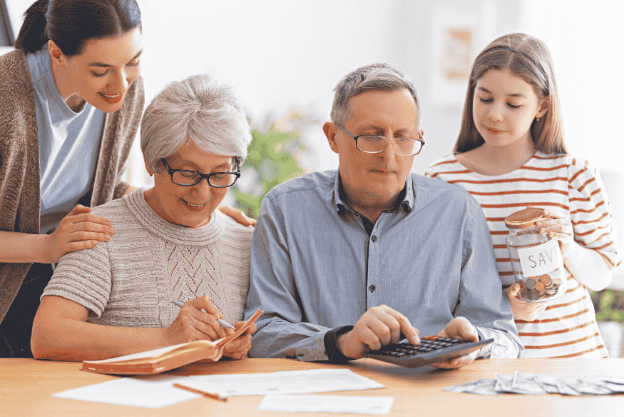 Famille multigénérationnelle planifiant son budget à la maison avec carnet, calculatrice et bocal d’économies, illustrant l’importance d’un tableau de budget familial.