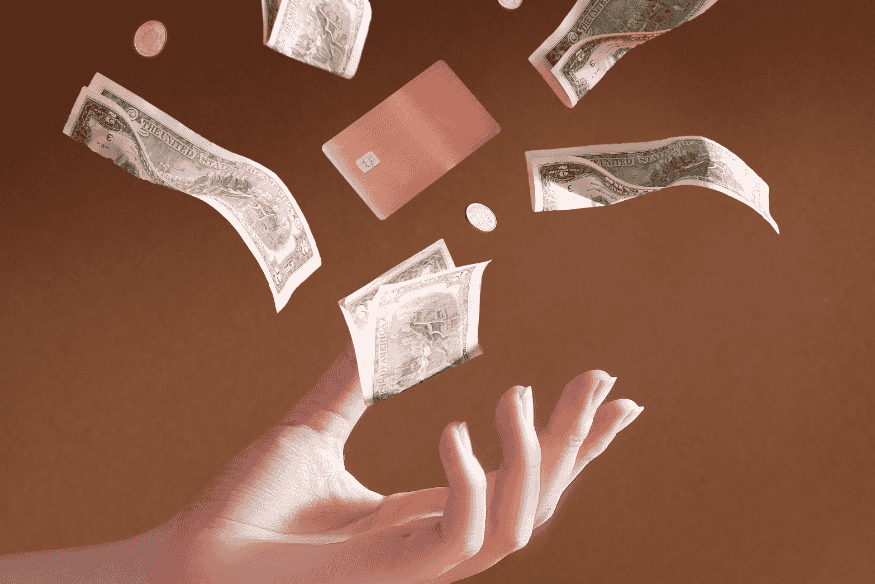 Main tendue avec des billets de banque et une carte bancaire en lévitation, symbolisant la transition entre espèces et paiements numériques en France.